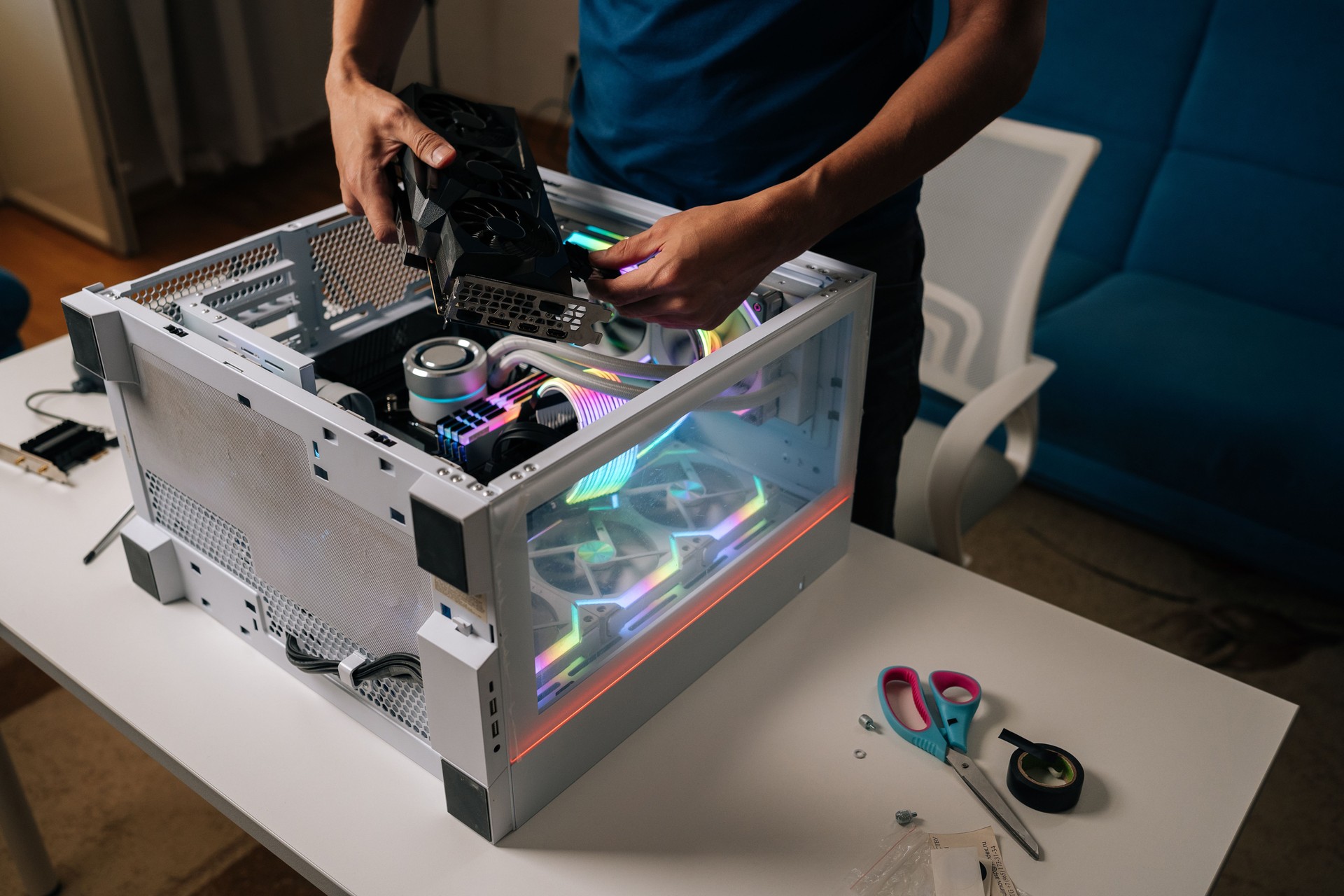 Unrecognizable computer technician installing new graphics card into modern custom-built pc with RGB lighting, enhancing gaming performance and visual experience.